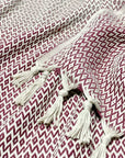 Stylish photo-shooting of a burgundy & beige colour cotton blanket with a knotted fringe.