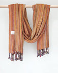 Crochet scarf with a blend of orange colours with knotted fringe and hand-twisted style on the stick.