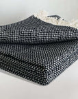 Stylish folded handwoven king-size blanket with a chain pattern in black & white colour.