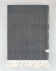 Folded handwoven king-size blanket with a chain pattern in black & white colour.