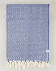 Folded handwoven blanket with a pearl pattern in blue colour.