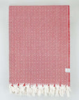 Folded handwoven blanket with a pearl pattern in red colour.
