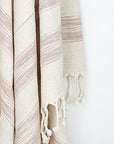 Close-up image of a scarf with linen & cotton blend in brown colour with knotted fringe.