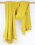 Cotton scarf is handwoven in plain mustard colour with knotted fringe and hand-twisted style on the stick.