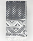 Folded double-sided a black colour towel with jacquard patterns.