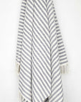 Cotton towel with navy stripes and hand-twisted & knotted fringe hanging.