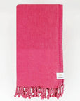 Folded beach towel in plain rose colour.