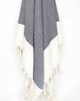 Diamond pattern towel in navy colour with knotted fringe hanging.