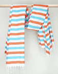 Towel with orange & blue horizontal stripes and hand-twisted & knotted fringe with hand-twisted style on the stick.
