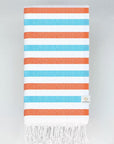 Folded towel with orange & blue horizontal stripes and hand-twisted & knotted fringe.