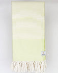 Folded a bitter lemon colour towel with white stripes and knotted fringe.