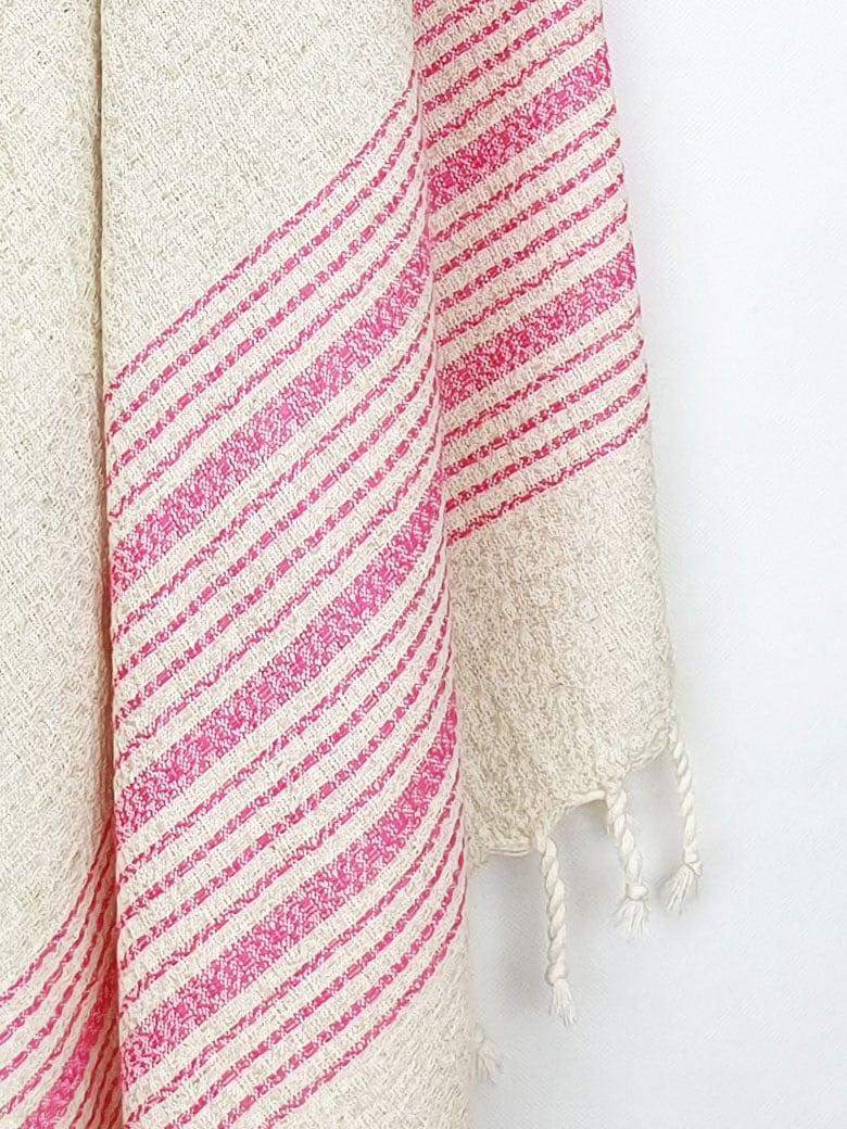 Close-up image of a pink colour with multiple stripes on a plain beige colour.