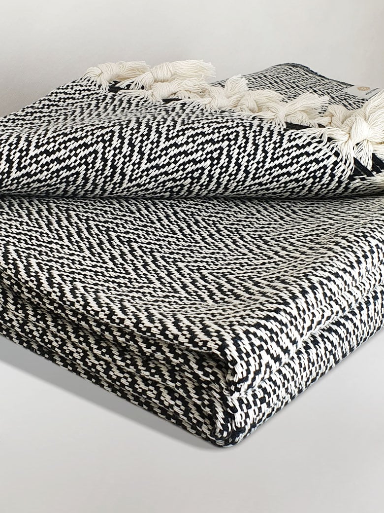 Stylish folded 100% cotton blanket with a  unique pattern in black & white colour.