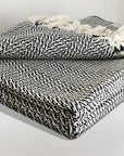 Stylish folded 100% cotton blanket with a  unique pattern in black & white colour.