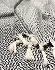 Stylish photo-shooting of a black & white colour 100% cotton blanket with a knotted fringe.