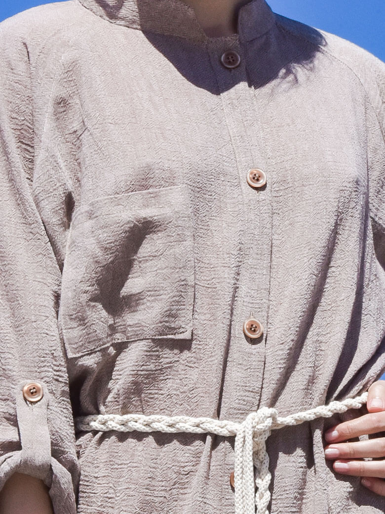 Close-up image of women's beige boho midi shirt dress with a beige rope belt and long sleeves.
