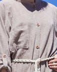 Close-up image of women's beige boho midi shirt dress with a beige rope belt and long sleeves.