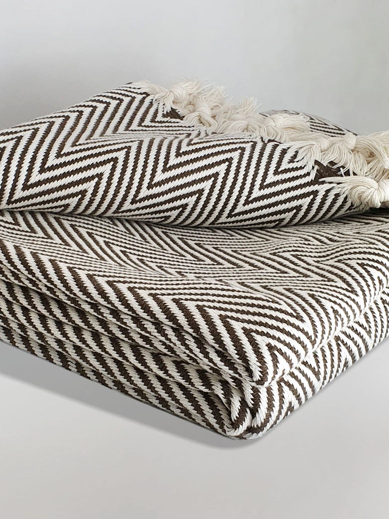 Stylish folded handwoven extra large blanket with a chevron pattern in brown colour.