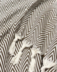 Stylish photo-shooting of a brown colour extra-large blanket with a tasselled edge.