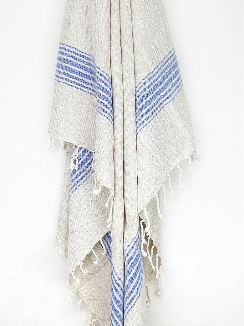 Beige linen scarf with a cotton blend and blue colour stripes with knotted fringe hanging.