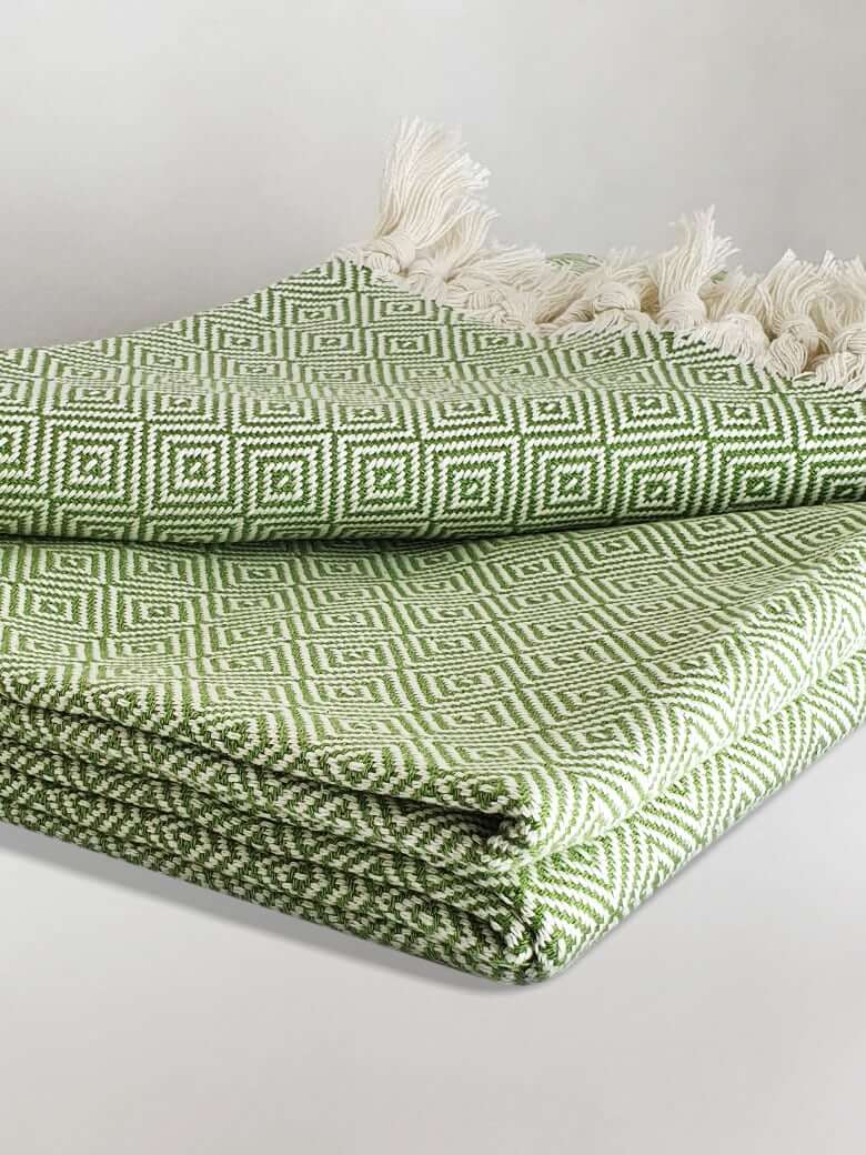 Stylish folded handwoven large-size blanket with a diamond pattern in green colour.