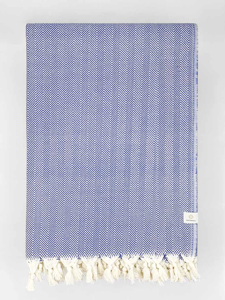 Folded handwoven %100 cotton blanket with a herringbone pattern in blue colour.