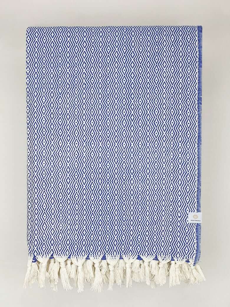 Folded handwoven blanket with a pearl pattern in blue colour.