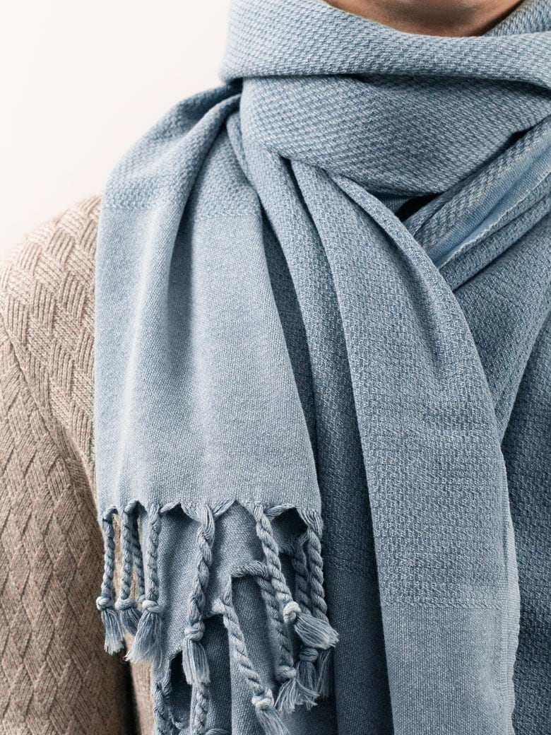 Close-up image of a 100% cotton scarf in plain grey colour with knotted fringe.