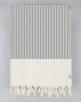Folded soft cotton blanket with a gentle waves pattern in black colour.