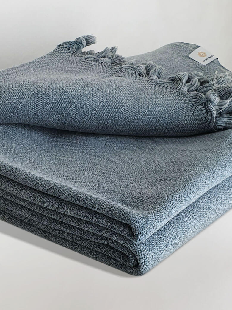 Stylish folded strong cotton blanket with a simple pattern in grey colour.