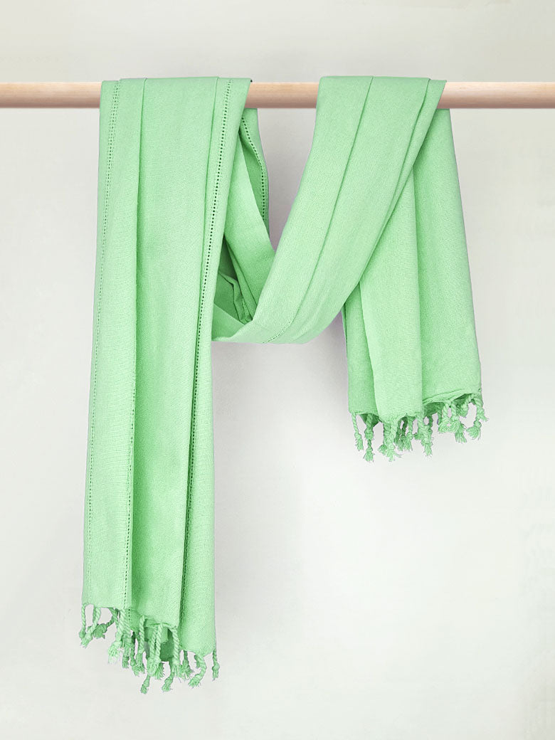 Cotton scarf in plain green colour with knotted fringe and hand-twisted style on the stick.