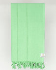Folded cotton scarf in plain green colour.