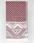 Folded double-sided a maroon colour towel with jacquard patterns.