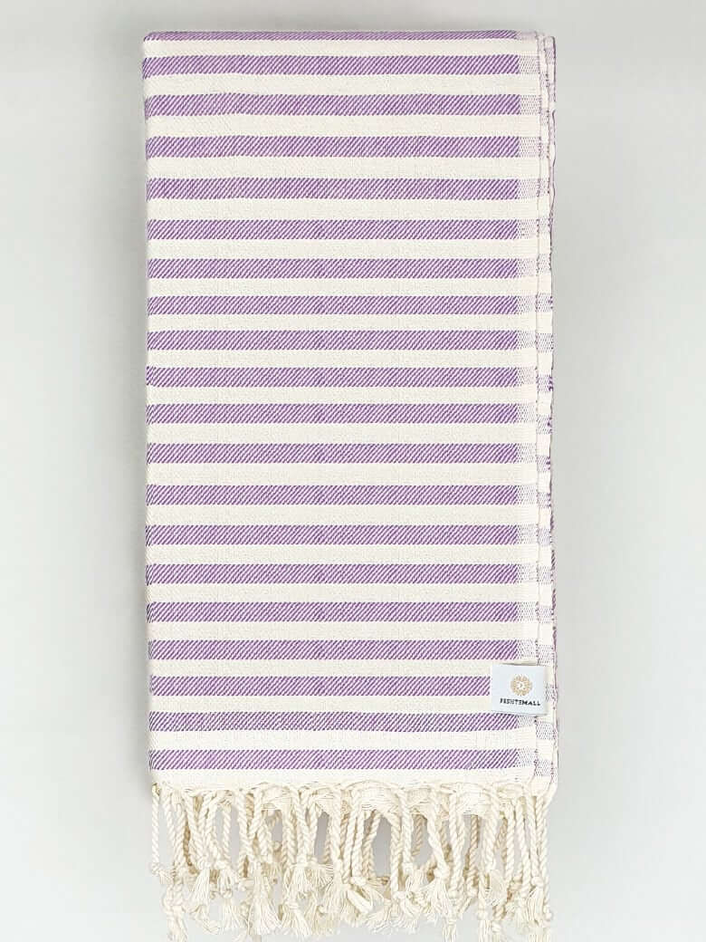 Folded cotton towel in plain lilac colour.