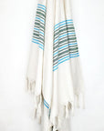 Close-up image of cotton & linen towel with green stripes & knotted fringe.