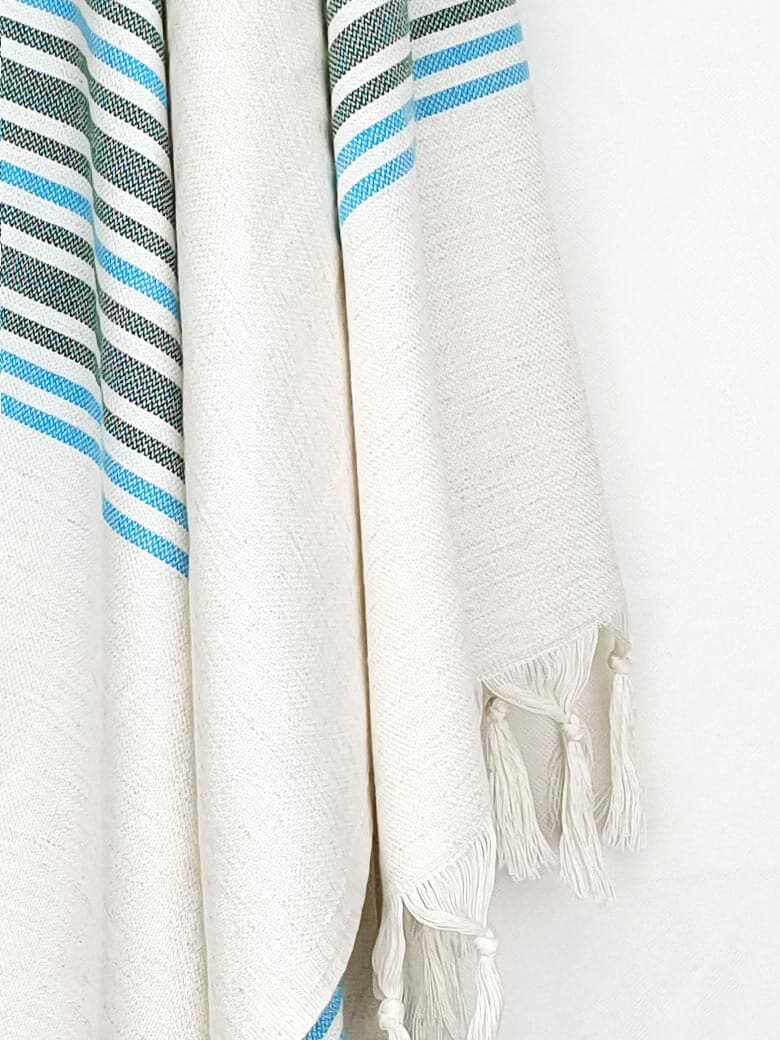 Cotton & linen towel with green stripes & knotted fringe hanging.