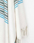 Cotton & linen towel with green stripes & knotted fringe hanging.