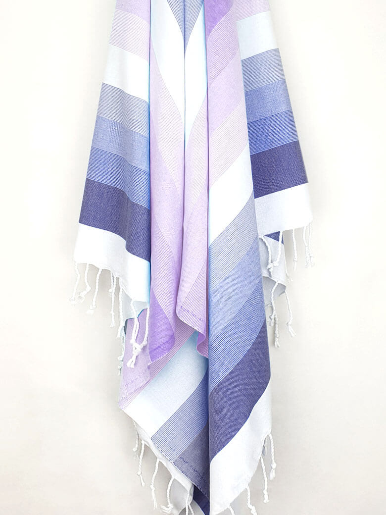 Beach towel with stripe navy tonal colours and hand-twisted & knotted fringe hanging.