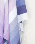 Close-up image of a beach towel with stripe navy tonal colours and twisted & knotted fringe.