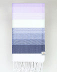 Folded a beach towel with stripe navy tonal colours and knotted fringe.