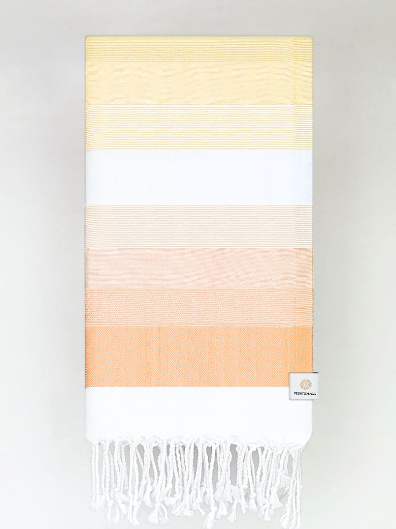 Folded a beach towel with stripe orange tonal colours and knotted fringe.