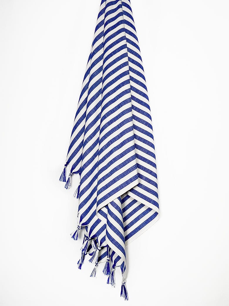 Large towel with blue thick stripes colour and knotted fringe hanging.