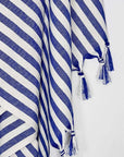 Close-up image of a large towel with blue thick stripes colour and knotted fringe.