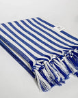 Side image of a large towel with blue thick stripes colour and knotted fringe.
