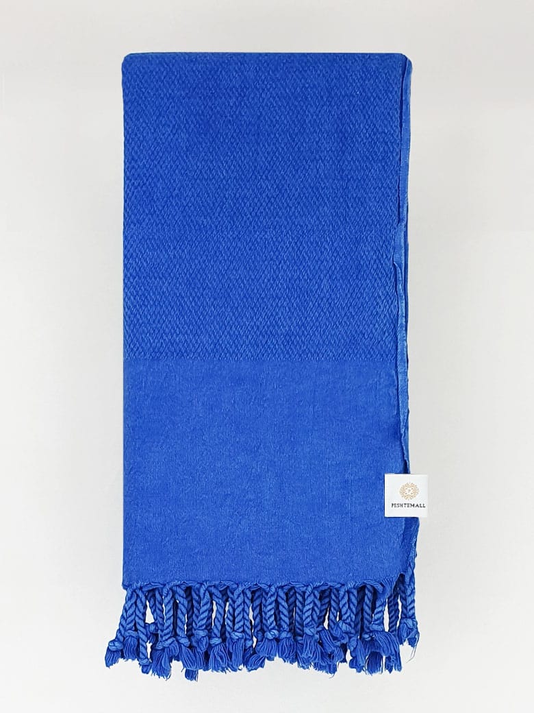 Folded beach towel in plain blue colour.