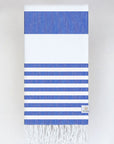 Folded beach towel with blue and white colours stripes and hand-twisted & knotted fringe.