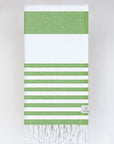 Folded beach towel with green and white colours stripes and hand-twisted & knotted fringe.