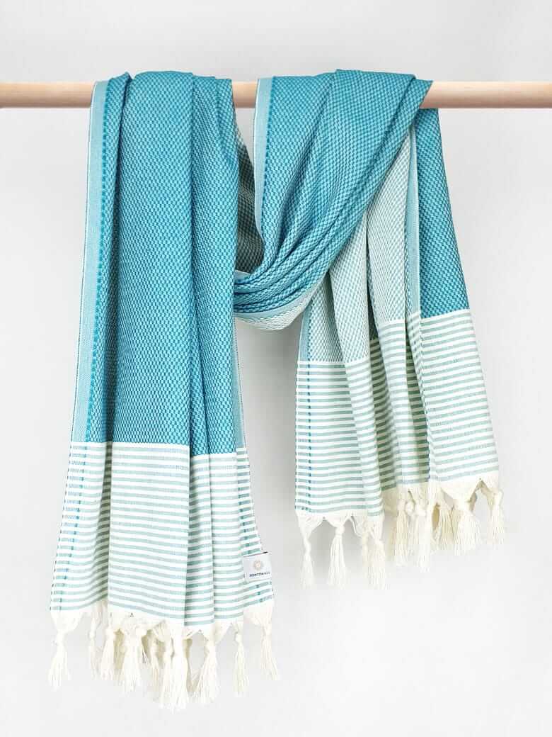 Towel in sea green colour with horizontal stripes and knotted fringe with hand-twisted style on the stick.