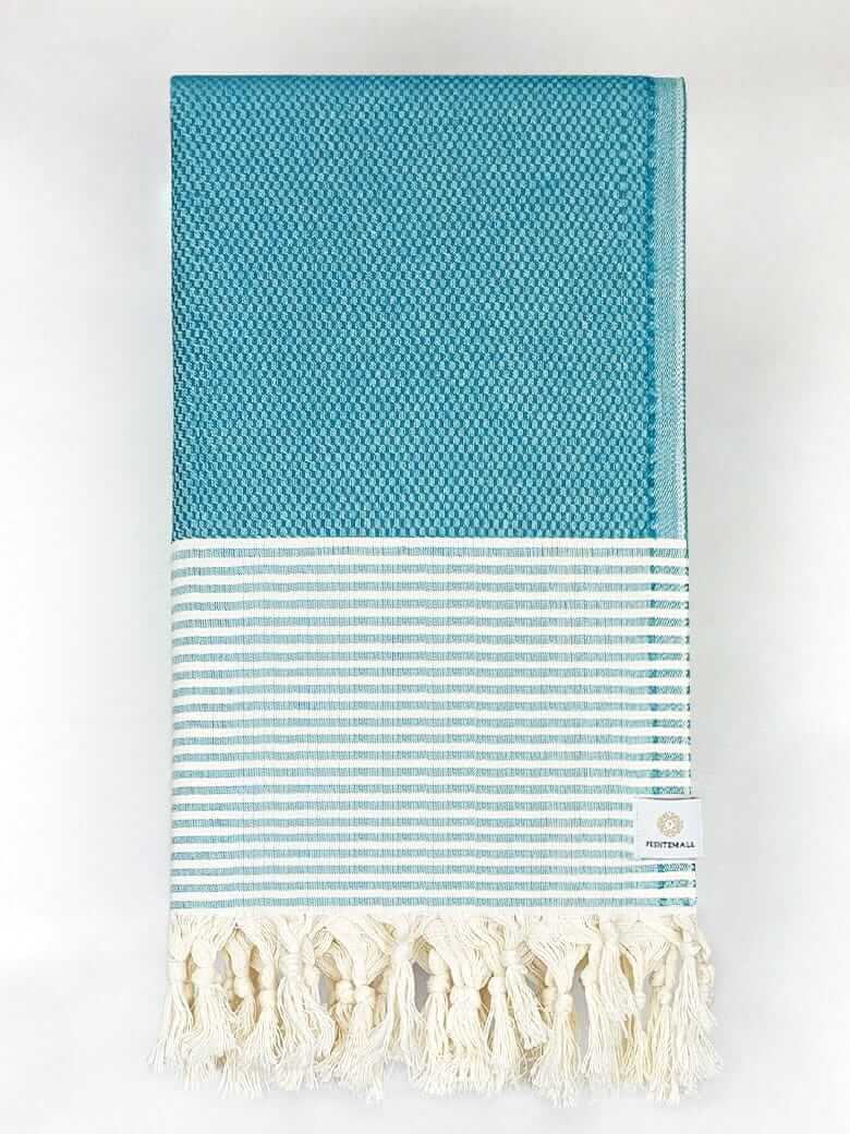 Folded towel in sea green colour with horizontal stripes and knotted fringe.