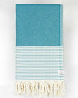 Folded towel in sea green colour with horizontal stripes and knotted fringe.